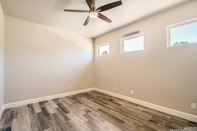 unfurnished room featuring dark wood-style floors, baseboards, ceiling fan, and a textured ceiling