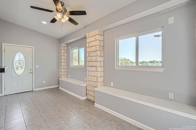 entryway featuring light tile patterned floors, ceiling fan, vaulted ceiling, and baseboards