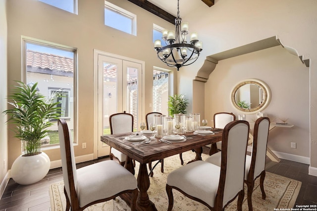 dining area featuring dark wood-style floors, a notable chandelier, french doors, and baseboards