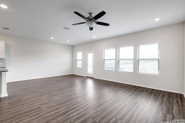 9416 Tennant Ln, Converse, TX 78109 - unfurnished living room featuring dark wood finished floors, a ceiling fan, visible vents, and baseboards