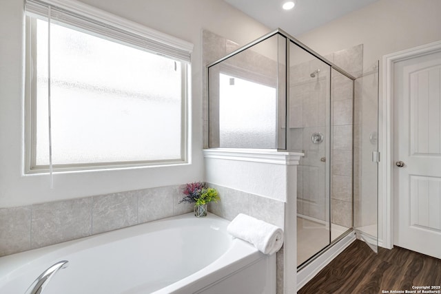 9416 Tennant Ln, Converse, TX 78109 - bathroom with a garden tub, a stall shower, and wood finished floors