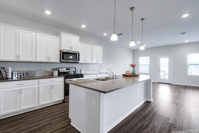 9416 Tennant Ln, Converse, TX 78109 - kitchen featuring dark wood finished floors, stainless steel appliances, backsplash, and a sink