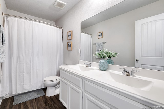 9416 Tennant Ln, Converse, TX 78109 - bathroom with toilet, a sink, wood finished floors, and visible vents