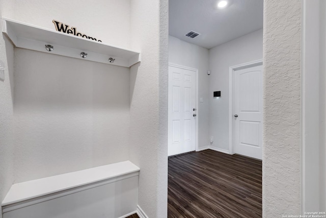 9416 Tennant Ln, Converse, TX 78109 - mudroom with dark wood-type flooring, visible vents, a textured wall, and baseboards