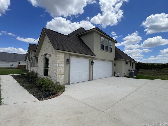 view of home's exterior featuring driveway, stone siding, a shingled roof, an attached garage, and stucco siding