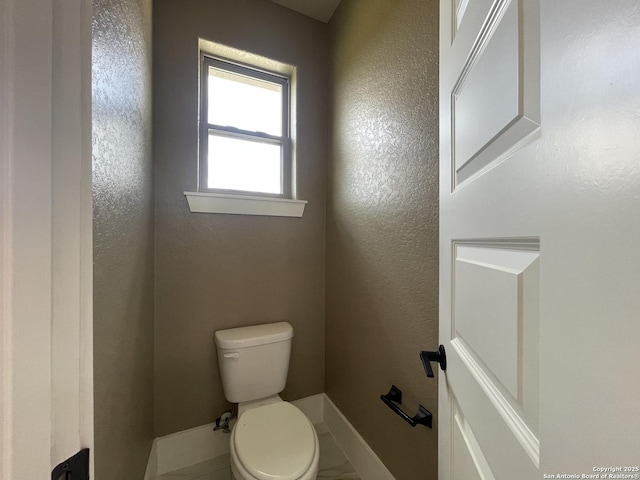 bathroom with baseboards and toilet