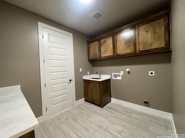 laundry room with a sink, cabinet space, washer hookup, electric dryer hookup, and gas dryer hookup