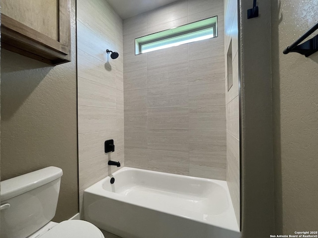full bathroom featuring a textured wall, toilet, and shower / bathtub combination