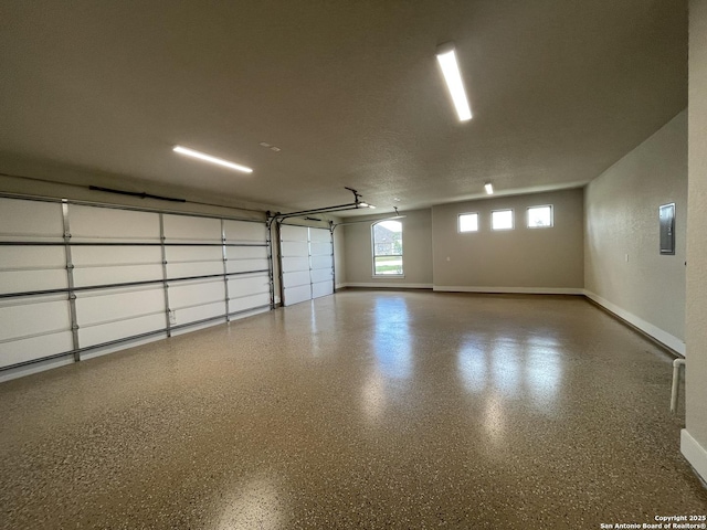 garage featuring baseboards and electric panel