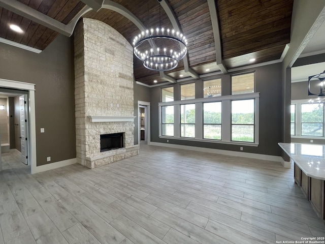 unfurnished living room featuring ornamental molding, a notable chandelier, baseboards, and wood ceiling