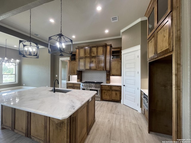 kitchen featuring double oven range, an inviting chandelier, crown molding, and a sink