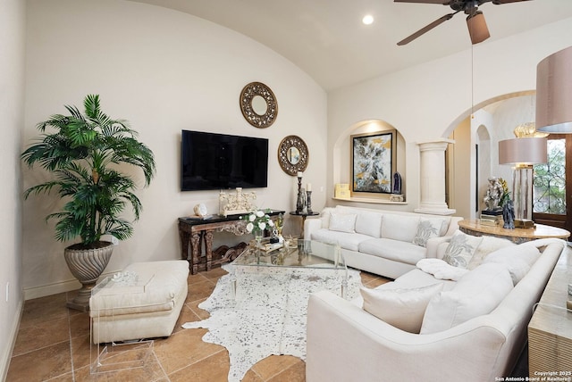 living room with lofted ceiling, ceiling fan, baseboards, arched walkways, and ornate columns