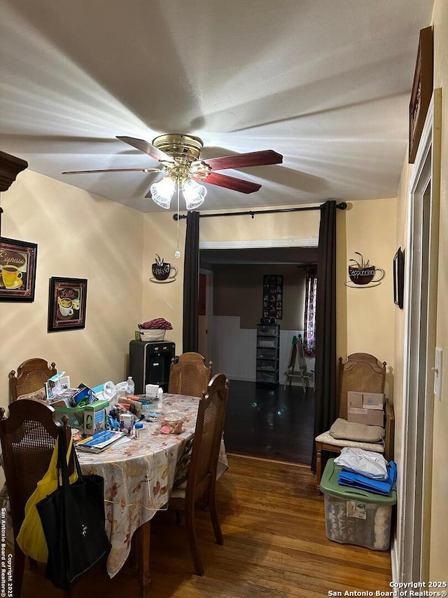 dining area with wood finished floors and a ceiling fan