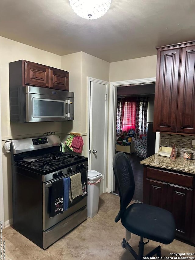 kitchen with dark brown cabinetry, light stone countertops, and stainless steel appliances