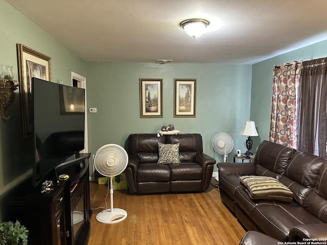 living room with visible vents and light wood-style flooring