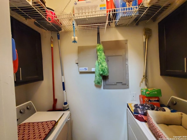 laundry room with cabinet space, washing machine and clothes dryer, and electric panel