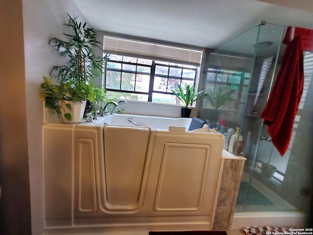full bathroom featuring a shower stall and a bath