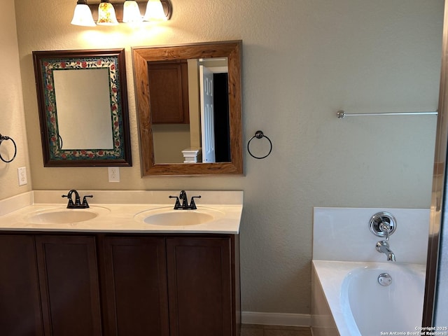 bathroom with double vanity, a tub to relax in, and a sink