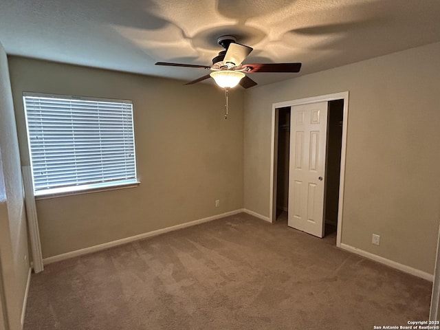 unfurnished bedroom with carpet, ceiling fan, baseboards, and a closet