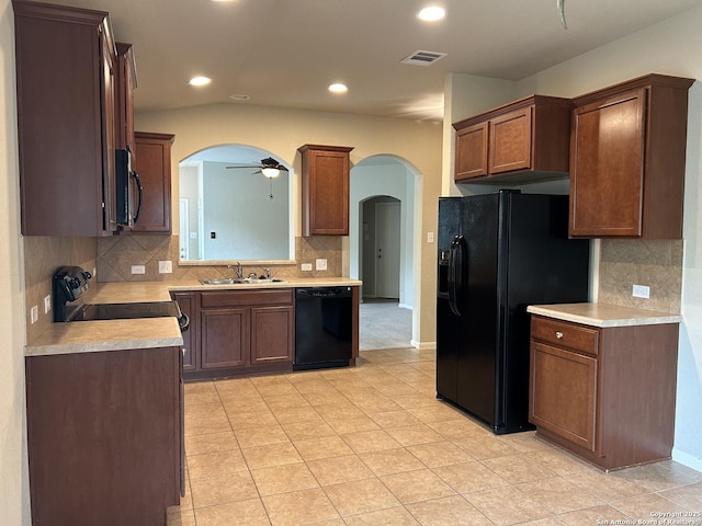 kitchen featuring black appliances, a sink, a ceiling fan, and arched walkways