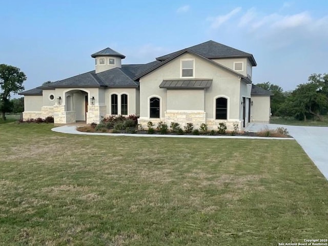 view of front of property featuring stucco siding, a front lawn, and stone siding