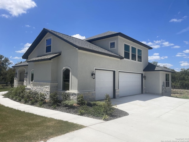 view of home's exterior featuring driveway, stone siding, a standing seam roof, stucco siding, and a garage