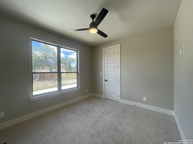 spare room featuring ceiling fan, a wealth of natural light, and baseboards