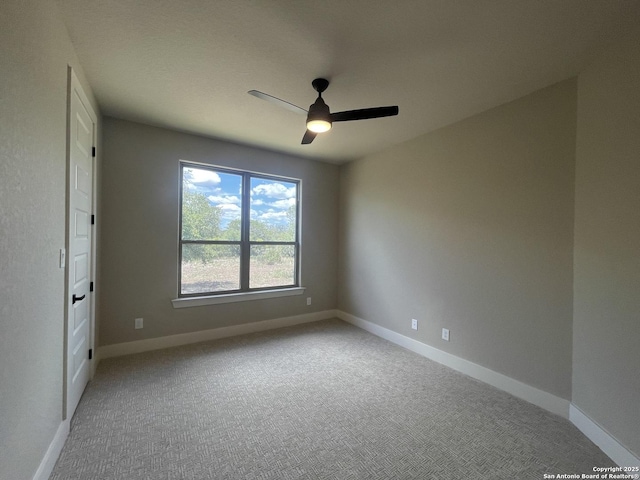 spare room featuring ceiling fan, carpet flooring, and baseboards