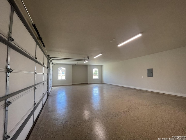 garage with baseboards and electric panel