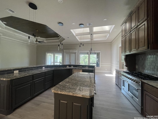 kitchen featuring appliances with stainless steel finishes, visible vents, crown molding, and a spacious island
