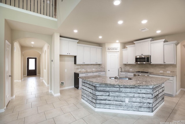 723 Decathlon, San Antonio, TX 78245 - kitchen with a sink, stainless steel appliances, decorative backsplash, visible vents, and arched walkways