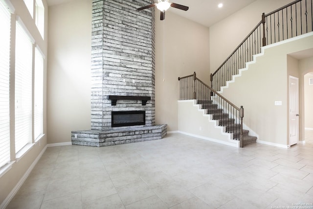 723 Decathlon, San Antonio, TX 78245 - unfurnished living room with a wealth of natural light, ceiling fan, a fireplace, and a towering ceiling
