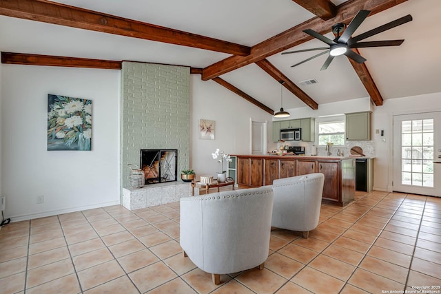 living area with light tile patterned floors, visible vents, ceiling fan, a brick fireplace, and vaulted ceiling with beams