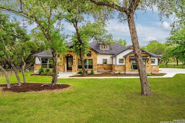 view of front of house featuring brick siding, board and batten siding, a front lawn, and roof with shingles