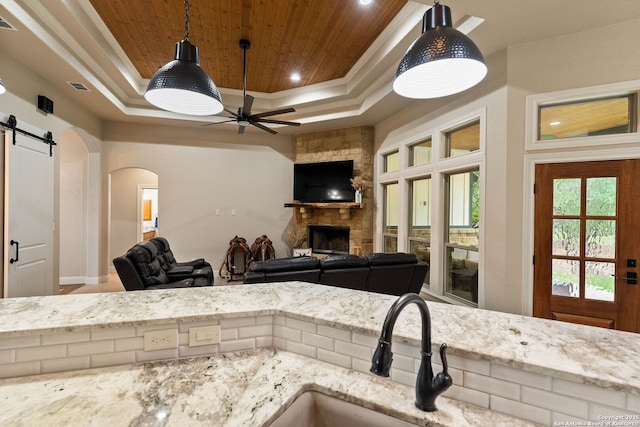 kitchen with a fireplace, a tray ceiling, and wooden ceiling