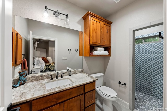 ensuite bathroom featuring tiled shower, toilet, connected bathroom, and vanity