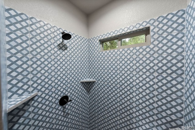 details featuring a tile shower and stucco siding