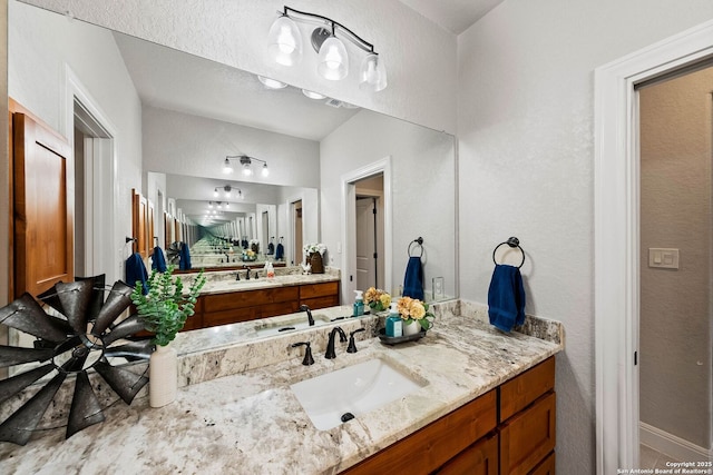 bathroom featuring baseboards, visible vents, and vanity