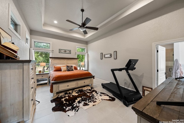 bedroom with light tile patterned floors, ceiling fan, and a raised ceiling