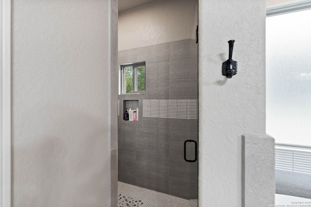 full bathroom with a shower stall and a textured wall