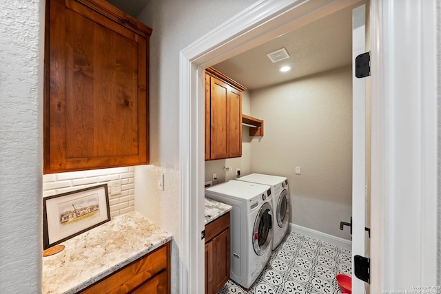clothes washing area featuring cabinet space, washing machine and dryer, light tile patterned flooring, visible vents, and baseboards
