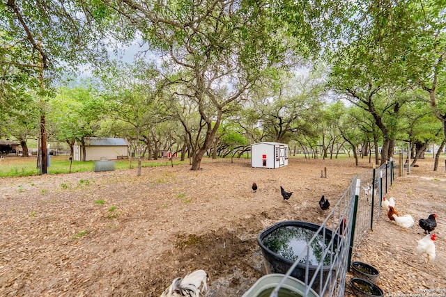 view of yard with fence, an outdoor structure, and a shed