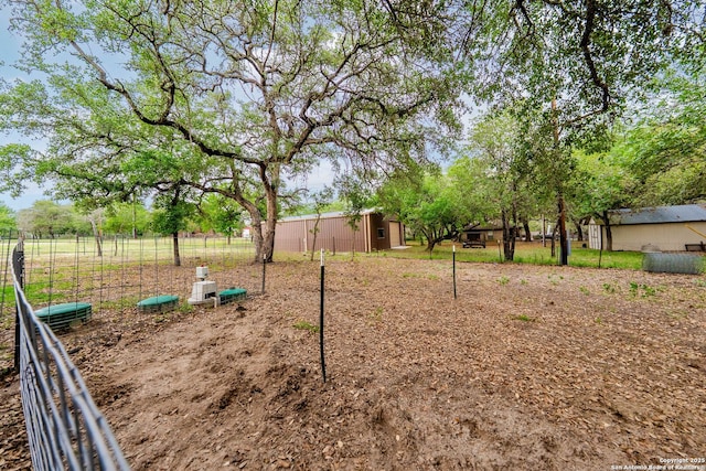 view of yard with fence and an outdoor structure