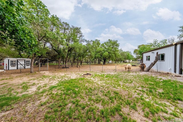 view of yard featuring fence and an outbuilding