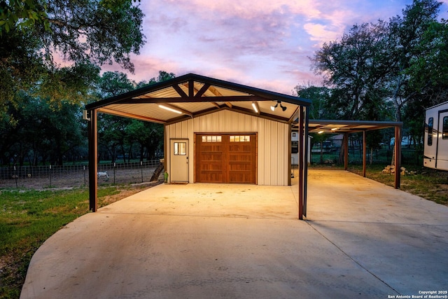 garage featuring a detached garage and fence