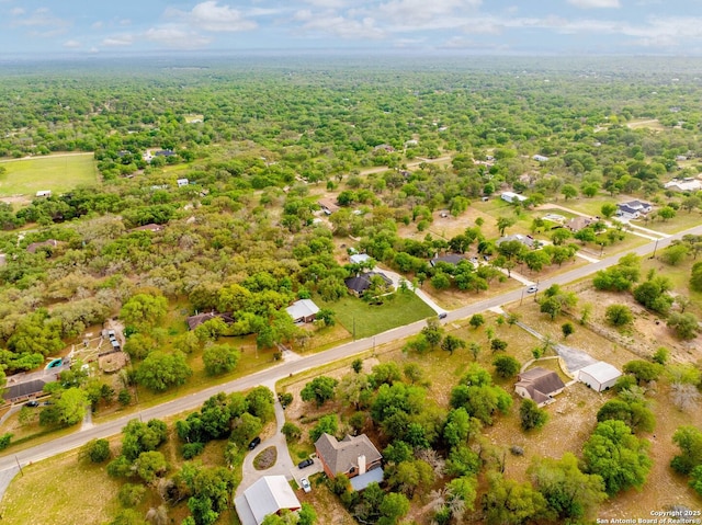 bird's eye view with a wooded view
