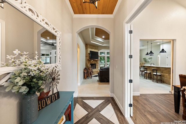corridor featuring recessed lighting, wooden ceiling, crown molding, baseboards, and arched walkways