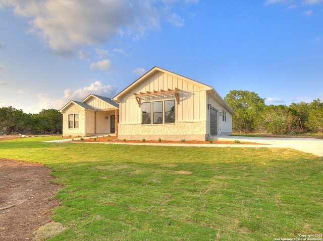 view of front facade featuring board and batten siding, a front lawn, and stone siding