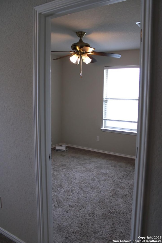 unfurnished room with ceiling fan, baseboards, and carpet floors