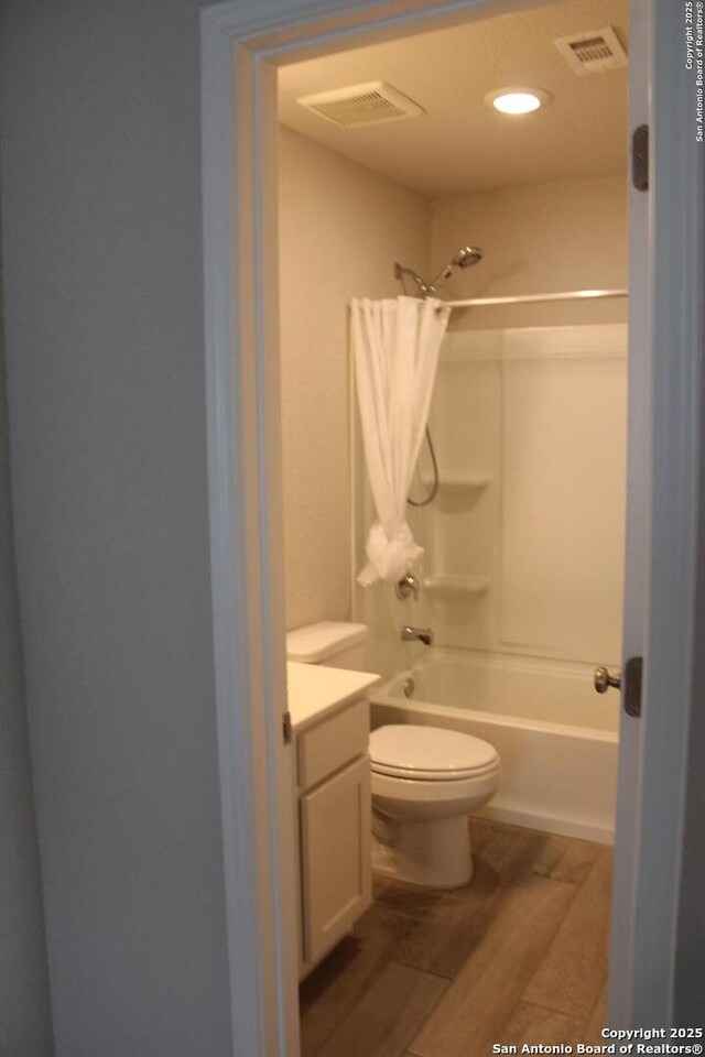 bathroom featuring visible vents, wood finished floors, toilet, and vanity